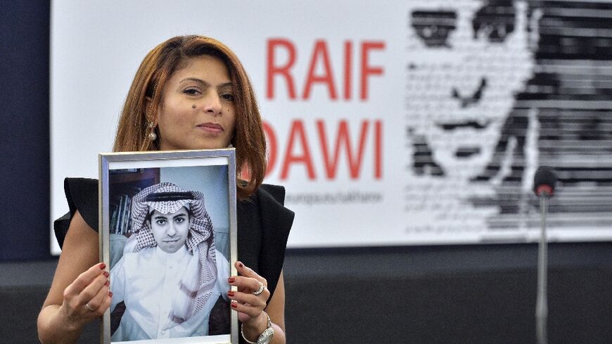 Ensaf Haidar holds a picture of her husband, Saudi blogger Raif Badawi, after accepting the European Parliament's Sakharov human rights prize on his behalf