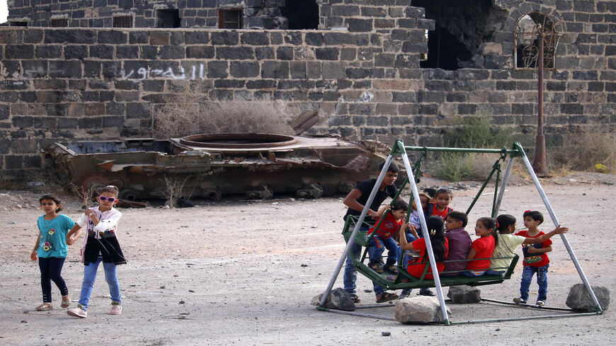 Children play on a swing on the first day of Eid al-Adha, in the opposition-held southern city of Daraa, Syria, Aug. 21, 2018.