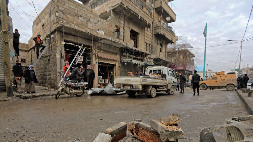 People gather around a damaged building in the Turkish-controlled city of al-Bab in Syria's northern Aleppo province on the border with Turkey on Feb. 2, 2022, following reported artillery shelling. 