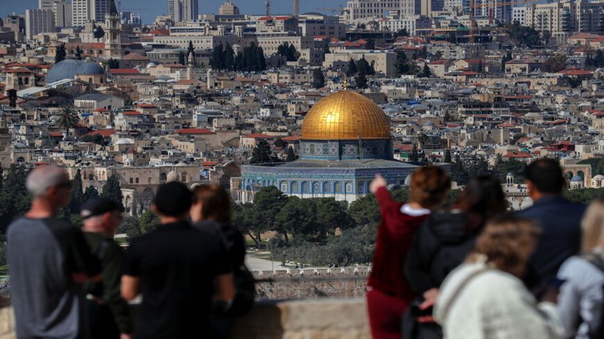 Tourists stand at the Mount of Olives