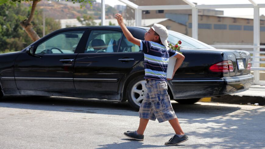 A Syrian refugee child sells flowers in the street in the northern Lebanese city of Tripoli.