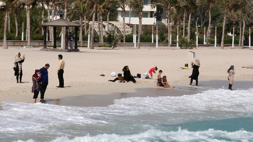 Tourists sit on the beach in Iran's resort island of Kish, which Tehran hopes will host football fans coming to the 2022 World Cup in nearby Qatar, seen here in this 2016 photograph