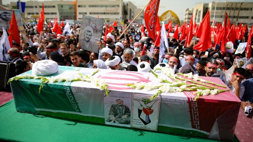 Mourners gather around the flag-draped casket of Iranian Shiite Muslim cleric Mohammad Aslani for his funeral in the northeastern city of Mashhad