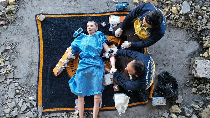 Members of the Syrian White Helmets use a dummy to demonstrate rescue skills in an instructive film intended for Ukrainians