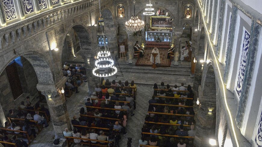 Christian worshippers attend mass at the Mar Tuma Syriac Catholic Church in Iraq's northern city of Mosul on April 30, 2022, for the first time since its restoration after it was ransacked by Islamic State group jihadists