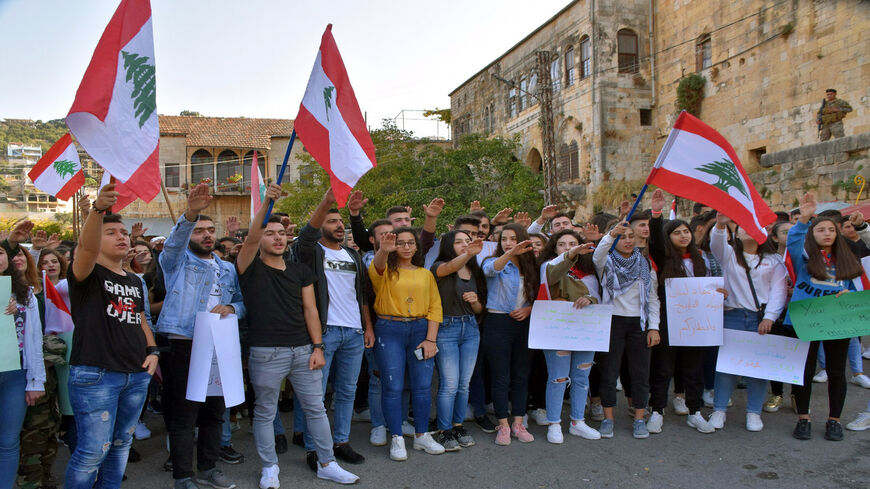 Lebanese students wave the national flag during an anti-government demonstration in the southern village of Hasbaya, Lebanon, Nov. 8, 2019.