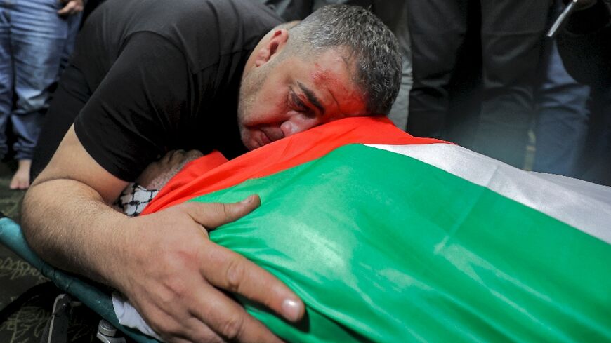 The brother of Palestinian lawyer Muhammad Hassan Muhammad Assaf mourns over his body during the funeral in the village of Kafr Laqif near Qalqilya in the northwest of the occupied West Bank