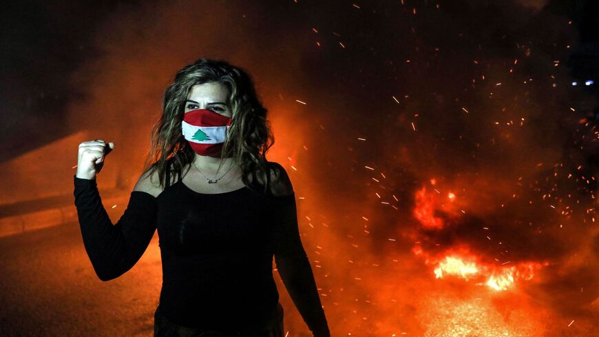 A demonstrator clad in a mask colored with the Lebanese flag.