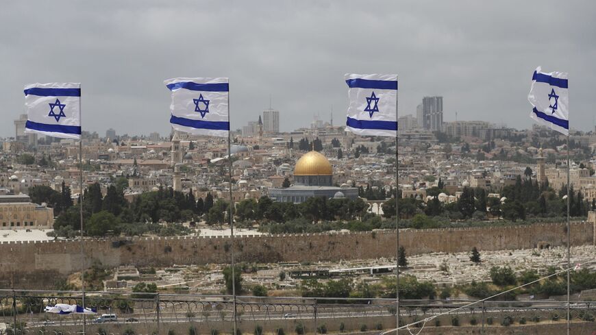 Israeli flags flutter at the military cemetery on the Mount of Olives.