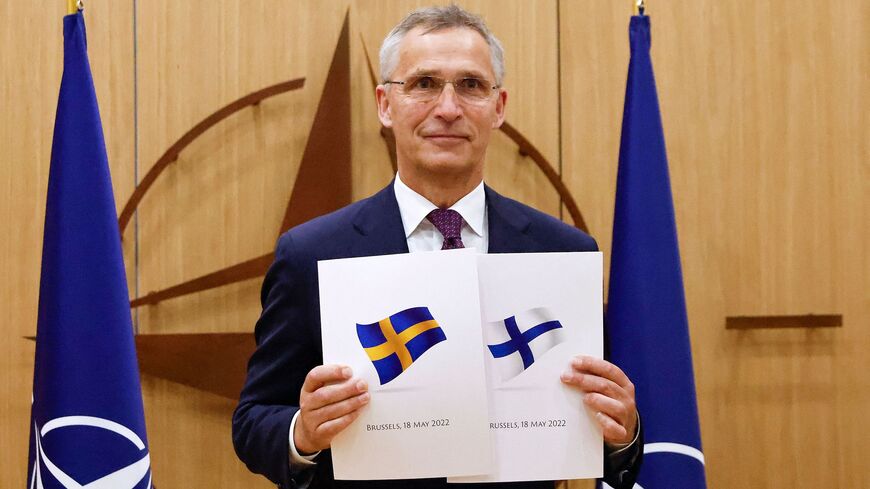 NATO Secretary-General Jens Stoltenberg poses with application documents presented by Finland's Ambassador to NATO Klaus Korhonen and Sweden's Ambassador to NATO Axel Wernhoff during a ceremony to mark Sweden's and Finland's application for membership in Brussels, on May 18, 2022.