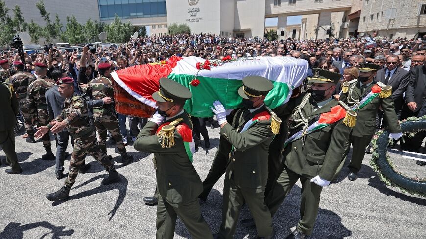 Palestinian honour guards carry the coffin of veteran Al Jazeera journalist Shireen Abu Akleh at the presidential headquarters in the West Bank city of Ramallah