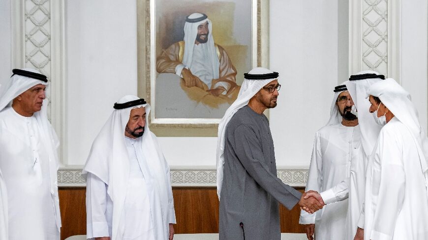 Sheikh Mohamed bin Zayed Al Nahyan (C) is congratulated with a handshake from Sheikh Saud bin Rashid al-Mualla of Umm al-Quwain (2nd-R) after his election as UAE President by the UAE's Federal Supreme Council as other council members look on