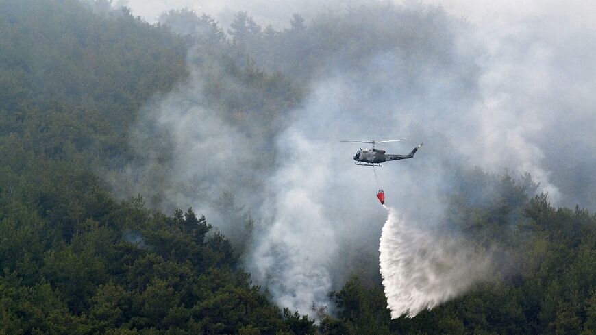 A firefighting helicopter drops water on the Batramaz forest fire in Lebanon's northern district on June 8