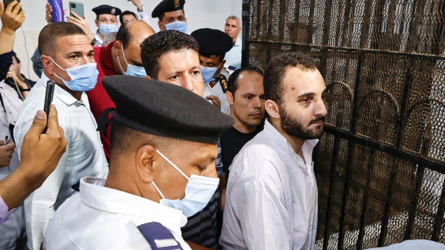 Mohamed Adel (C) is surrounded by guards after his first trial session at the Mansoura courthouse on June 26, 2022. He was sentenced to death on Tuesday for the murder of student Nayera Ashraf
