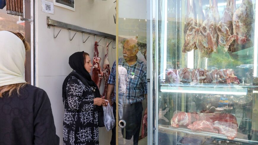 A woman shops at a butcher's in Tehran. Iran has been wrestling with rampant price growth for years, exceeding 30 percent annually every year since 2018, according to the International Monetary Fund