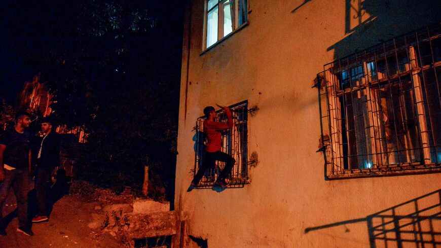 A youth breaks a window as men smash up shops and homes believed to be owned by Syrian families.