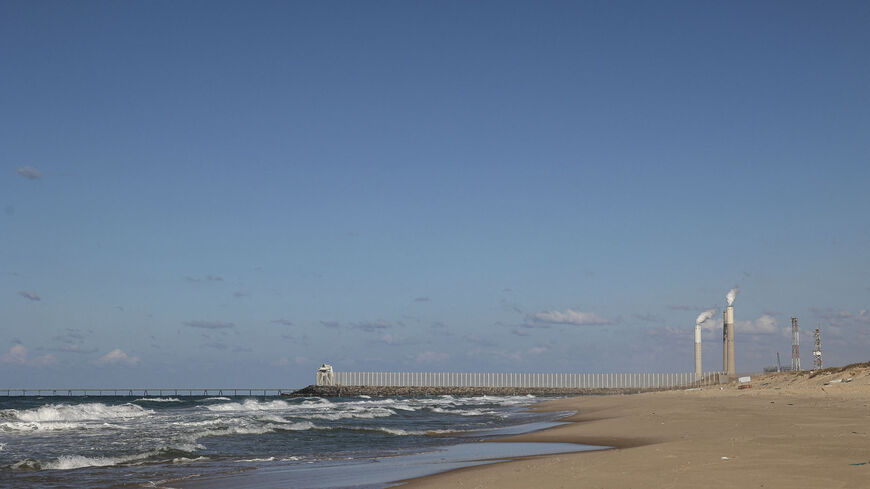 The beach in Beit Lahia looks out on the towers of an Israeli power plant in the city of Ashkelon, Gaza Strip, Dec. 15, 2021.