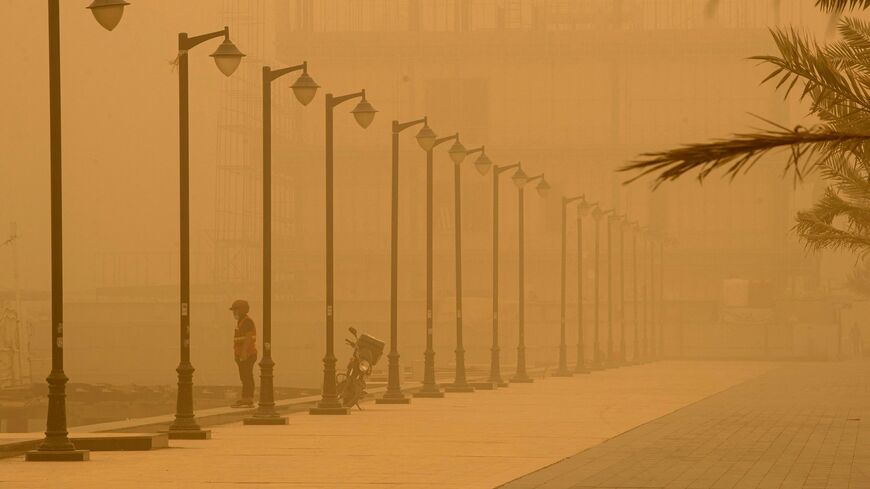 A man stands on the bank of the Shatt al-Arab waterway, formed at the confluence of the Euphrates and Tigris rivers, in Iraq's southern city of Basra on May 23, 2022, during a sandstorm sweeping the country. 