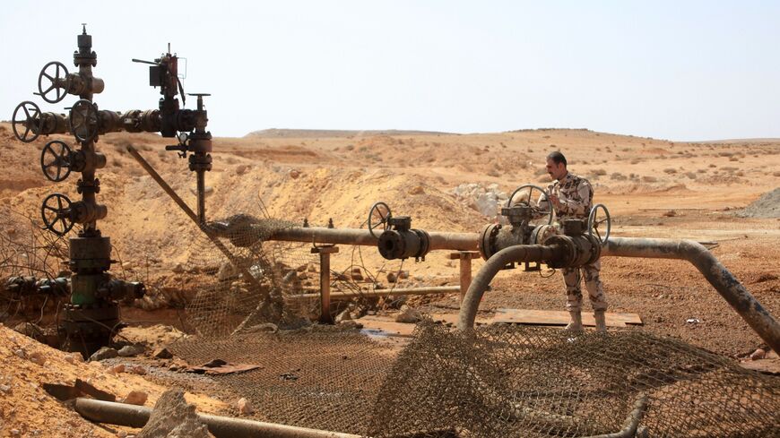 A member of the Syrian government forces stands next to a well at Jazel oil field near the ancient city of Palmyra.