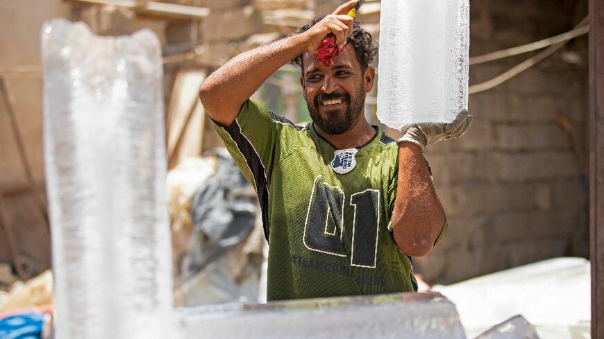 A man carries a block of ice at his stall in Iraq's southern city of Basra