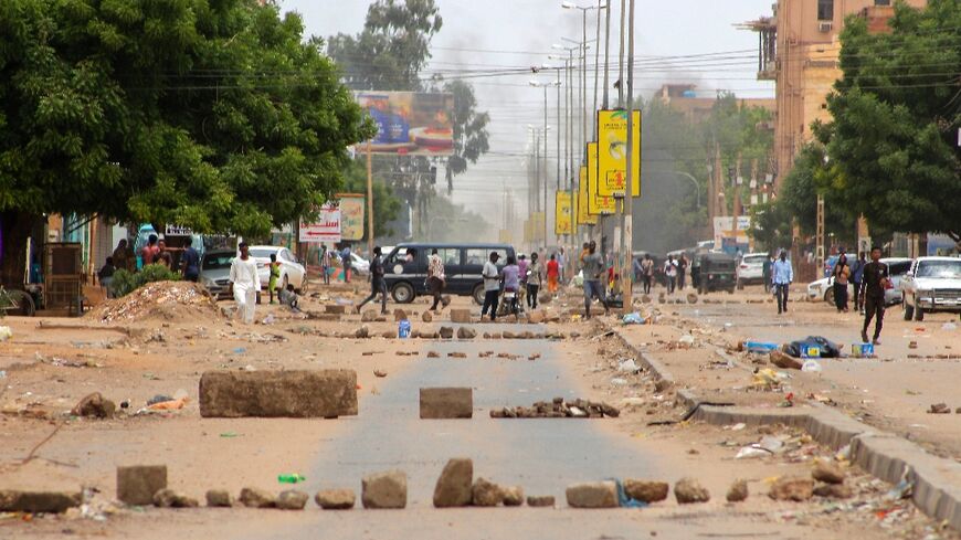 Smoke billows as Sudanese protesters take part in an anti-coup demonstration on a barricaded street in the Daym - Bashdar station area in central Khartoum, on July 17, 2022