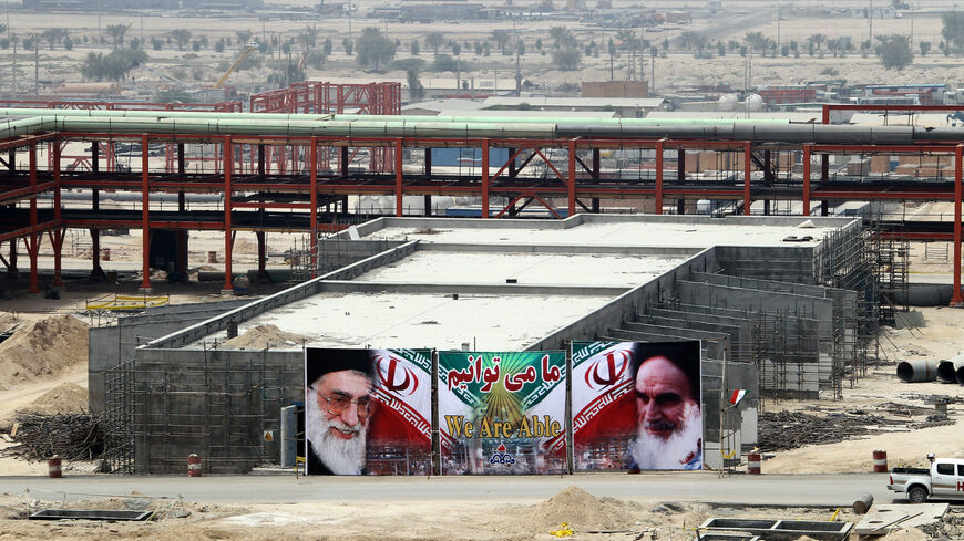 A huge banner bearing portraits of Iran's supreme leader Ayatollah Ali Khamenei (L) and his predecessor, the founder of the Islamic republic, Ayatollah Ruhollah Khomeini (R), is seen on a building being constructed at phase 15 and 16 of South Pars gas field development in the southern Iranian port town of Asaluyeh on July 19, 2010 as a top official announced that global energy majors are welcome to help develop oil and gas projects in Iran despite new sanctions imposed on the Islamic republic. AFP PHOTO/ATT