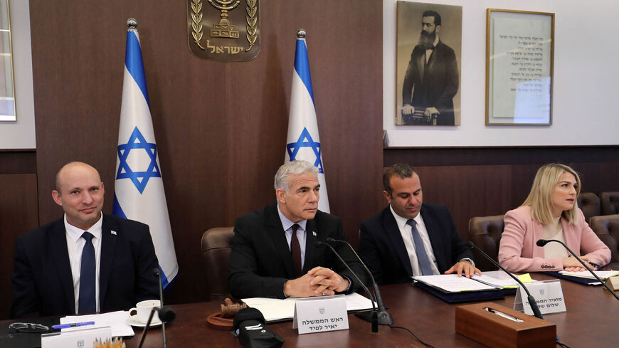 Israel's former Prime Minister Naftali Bennett, caretaker Prime Minister Yair Lapid and Cabinet Secretary Shalom Shlomo attend the first Cabinet meeting days after lawmakers dissolved parliament, Jerusalem, July 3, 2022.