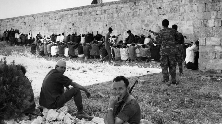 This file photo taken by an AFP photographer during the 1967 Six Day War shows Israeli soldiers standing guard by Jordanian and Palestinian prisoners of war along a wall at Al-Aqsa Mosque compound, May 16, 2017.