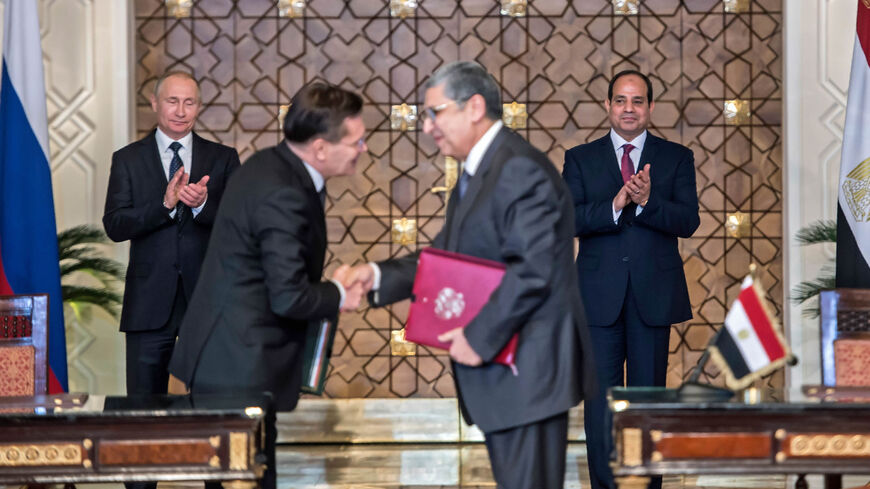 Egyptian President Abdel Fattah al-Sisi (back-R) and his Russian counterpart Vladimir Putin (back-L) applaud as Egypt's electricity and renewable energy minister, Mohamed Shaker (R), shakes hands with Alexey Likhachev, the director general of Russia's Atomic Energy Corporation Rosatom, after signing a bilateral agreement in Cairo, Egypt, Dec. 11, 2017.