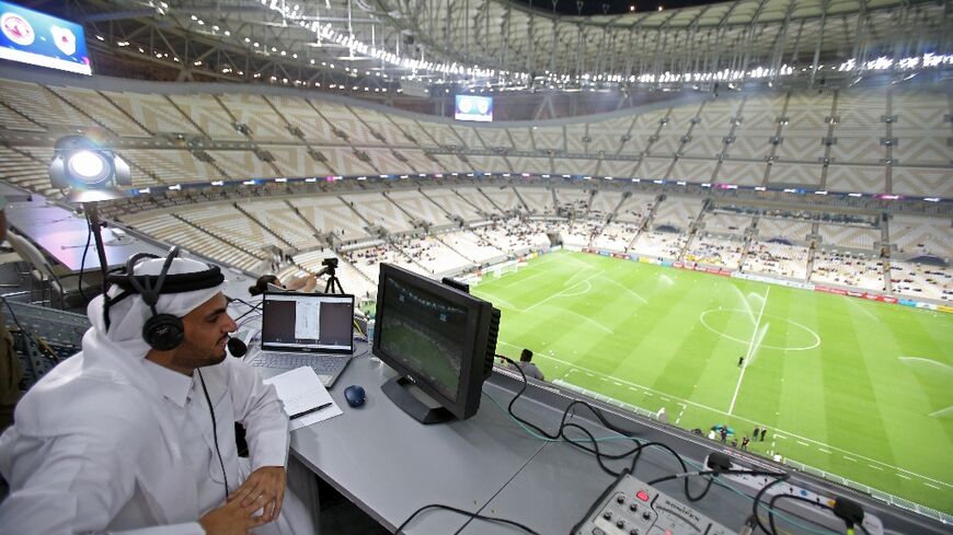 A commentator prepares for the Qatar Stars League match between Al-Arabi and Al-Rayyan at the Lusail stadium, the venue for the World Cup final