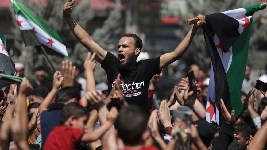 Syrians rally in opposition-held Al-Bab, on the border with Turkey in the northern Aleppo province following statements by the Turkish foreign minister