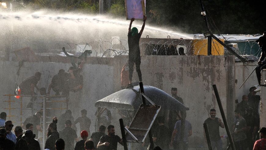 Iraqi security forces use a water cannon against supporters of the Coordination Framework to stop them entering the Green Zone on Monday