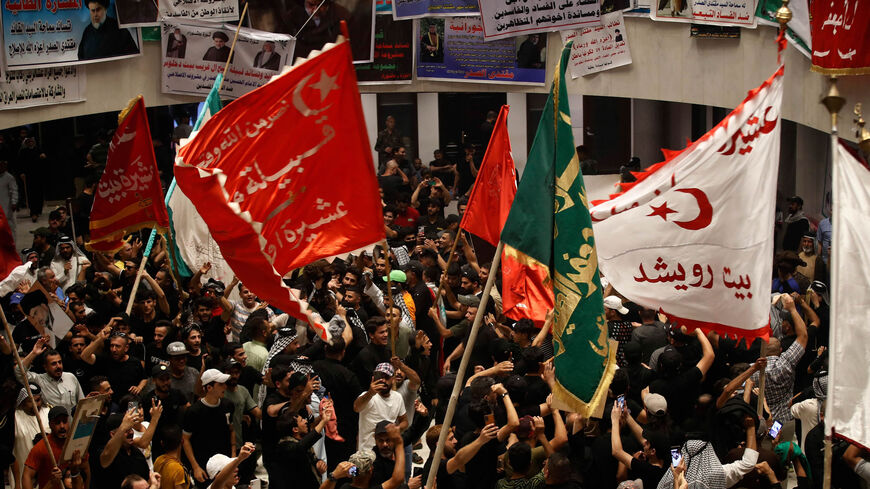 Supporters of Iraqi cleric Muqtada al-Sadr wave flags as they occupy the Iraqi parliament for a sixth consecutive day, in protest at a nomination for prime minister by a rival Shiite faction, Green Zone, Baghdad, Iraq, Aug. 4, 2022.