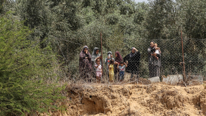 Palestinian women watch the funeral procession of members of the al-Nabahin family at al-Bureij refugee camp, after they were killed during the latest three-day conflict between Israel and Palestinian militants before a cease-fire, central Gaza strip, Aug. 8, 2022