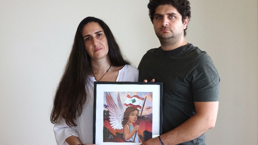 Paul and Tracy Naggear hold a framed drawing for their late daughter Alexandra, who was killed in the Beirut port blast of August 2020