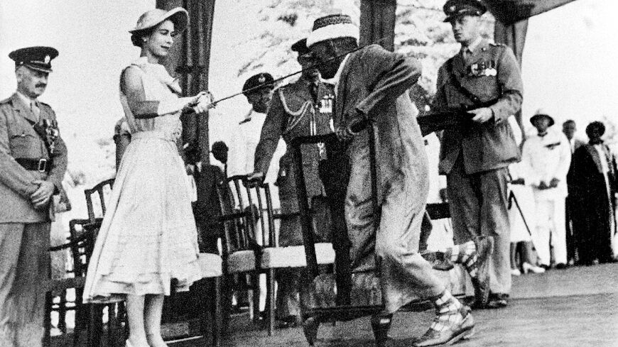 Yemen's councillor Sayyid Abubakr bin Shaikh Alkaff kneels before Queen Elizabeth II and is knighted during her visit to Aden, on April 29, 1954