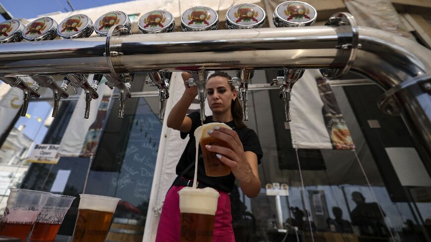 A bartender serves visitors at the annual beer festival in the Palestinian village of Taybeh in the Israeli-occupied West Bank