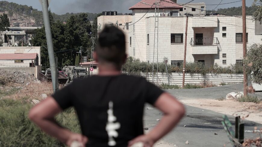 A Palestinian youth holds stones in readiness to hurl at Israeli soldiers  carrying out a raid in Jenin in which four people were killed