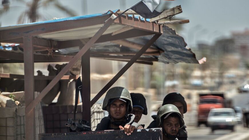 A picture taken on July 26, 2018 shows Egyptian policemen stand guarding a checkpoint on a road leading to the North Sinai provincial capital of El-Arish.