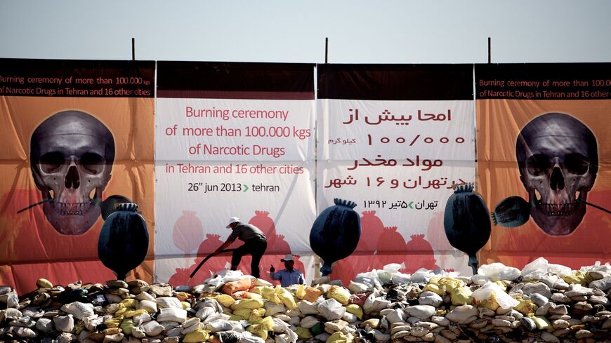 An Iranian man pours kerosene on a pile of drugs seized by authorities.