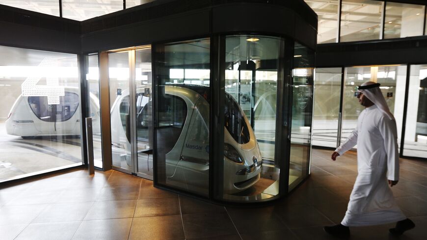 A man walks past an electric car in Masdar City, outside the rich Emirate of Abu Dhabi, on Oct. 7, 2015. 