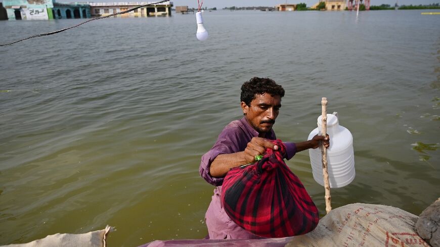 A man prepares to return home after heavy monsoon rains in Pakistan's Sindh province. Developing nations want funding from rich polluters to help them adapt to the impacts of global heating