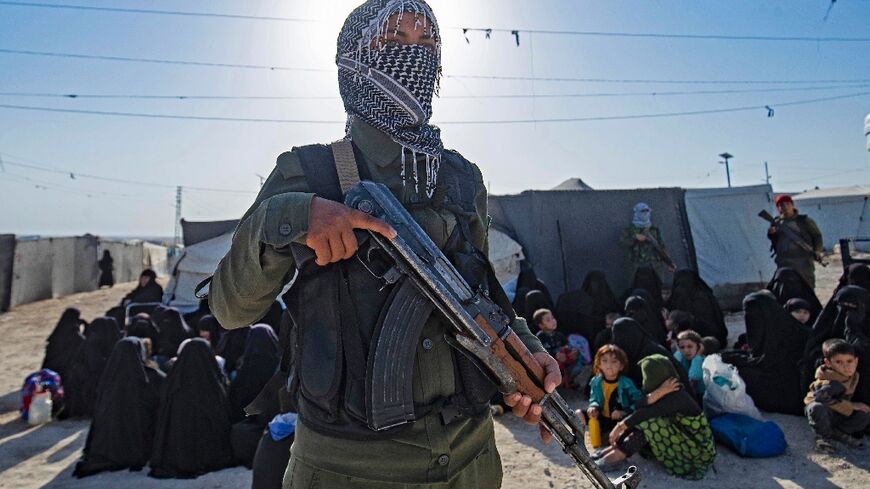 A Syrian Kurdish fighter stands guard during a security operation in late August in the sprawling Al-Hol camp for relatives of suspected Islamic State group fighters