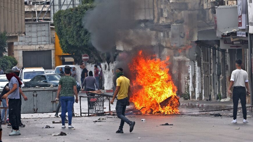 Palestinian protesters clash with Palestinian security forces in Nablus in the occupied West Bank on Tuesday following the arrest of two members of the Islamist group Hamas