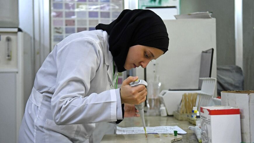 A lab technician tests samples for cholera at a hospital in Syria's main northern city of Aleppo