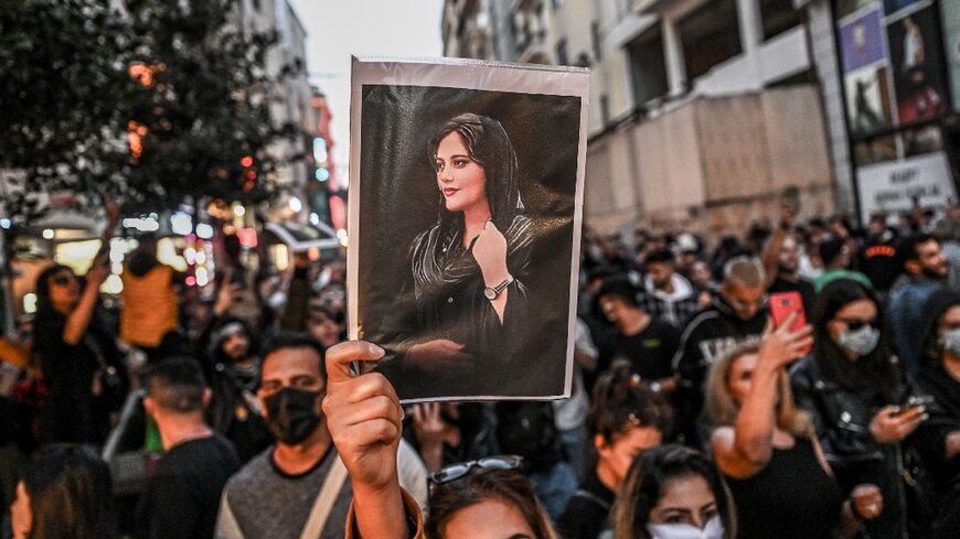 A protester in Istanbul holds aloft a photograph of Mahsa (Jhina) Amini, the young Kurdish woman who died in the custody of Iran's morality police who arrested her for an alleged infraction of the country's mandatory dress code for women