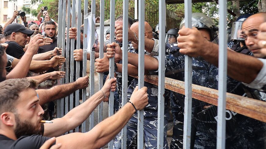 Protesters at the gates of the Justice Palace in Lebanon's capital Beirut on September 19, 202, demand the release of two people involved in a bank hold-up last week