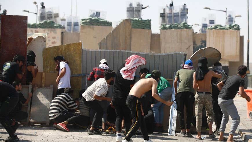 Iraqi anti-government demonstrators clash with security forces during a protest on the Jumhuriya (Republic) bridge leading to the capital Baghdad's high-security Green Zone on October 1, 2022