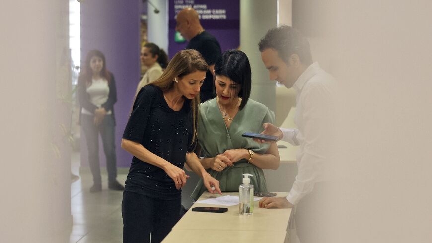 Lebanese MP Cynthia Zarazir (L) pictured inside Byblos Bank Antelias branch north of Beirut demanding access to her savings and refusing to leave the bank without her money