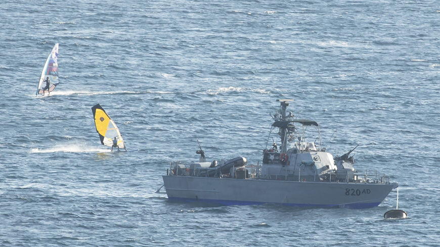 ROSH HANIKRA, ISRAEL - OCTOBER 11: Wind surfers surf by an Israeli navy boat in the mediterranean sea at the Israeli side of the border with Lebanon on October 11, 2022 in Rosh Hanikra, Israel. The agreement should resolve a territorial dispute in the eastern Mediterranean sea, where Lebanon wants to explore for natural gas. Israel is already extracting natural gas at nearby fields. (Photo by Amir Levy/Getty Images)